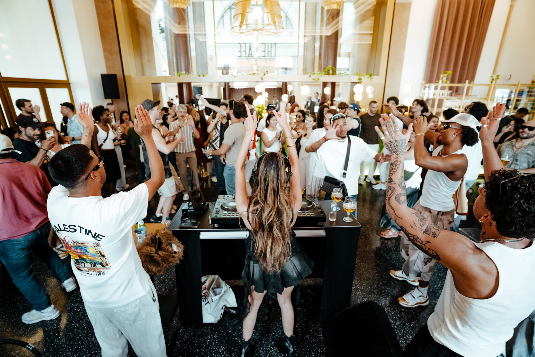 Daytime Social Club party with hands in the air around the DJ booth