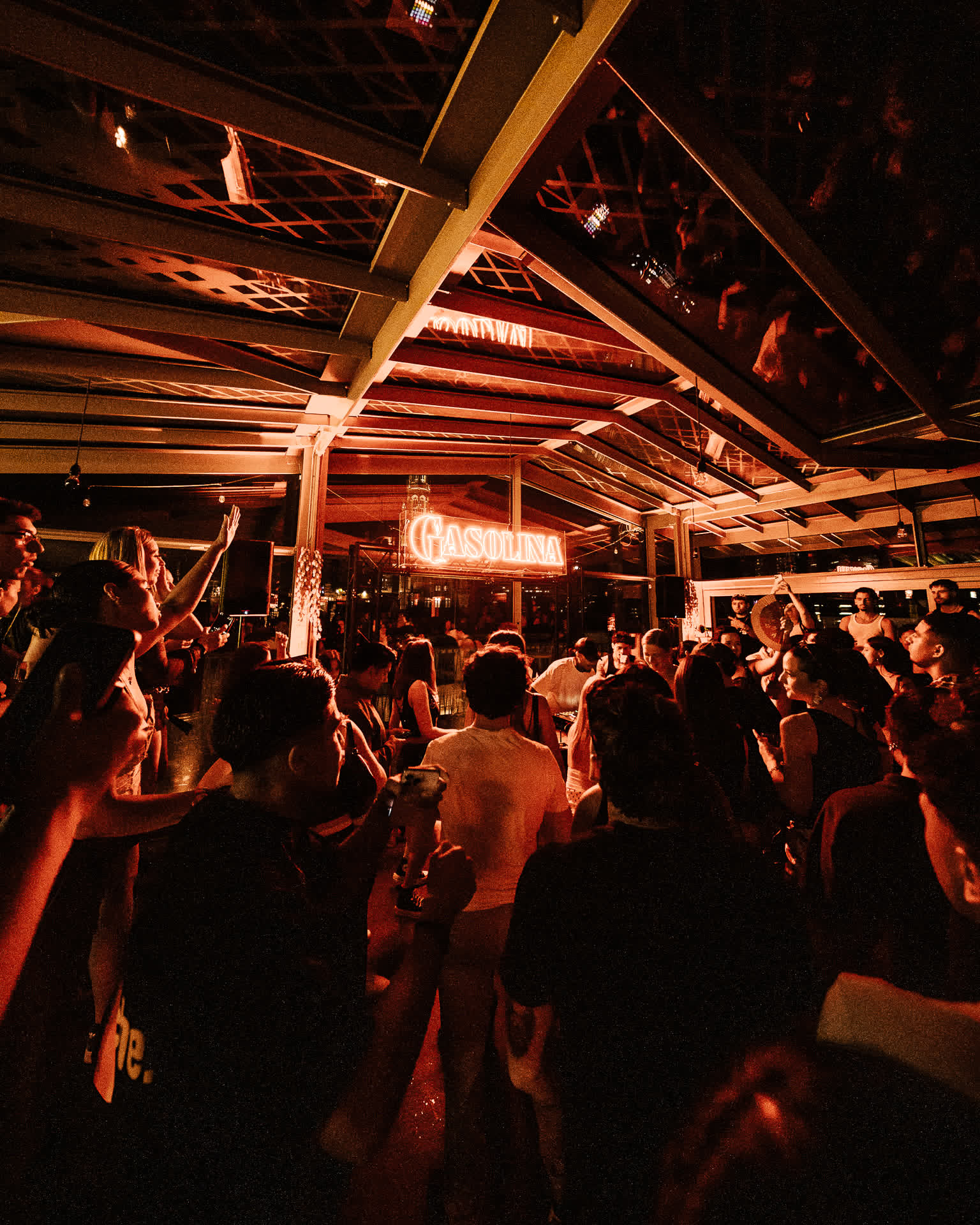 Warm orange light over the crowd under the wooden ceiling