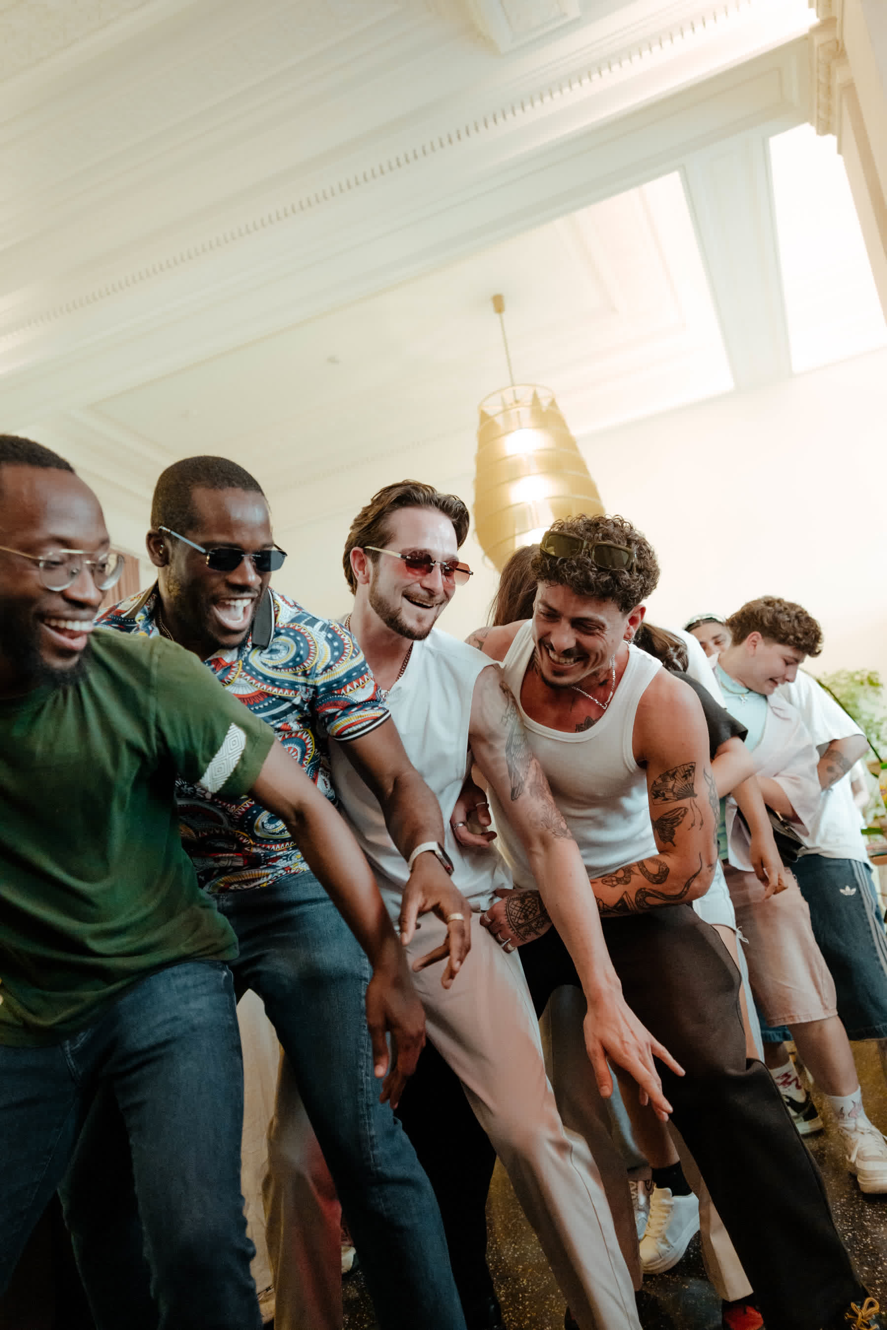 Friends laughing and dancing together in a bright venue