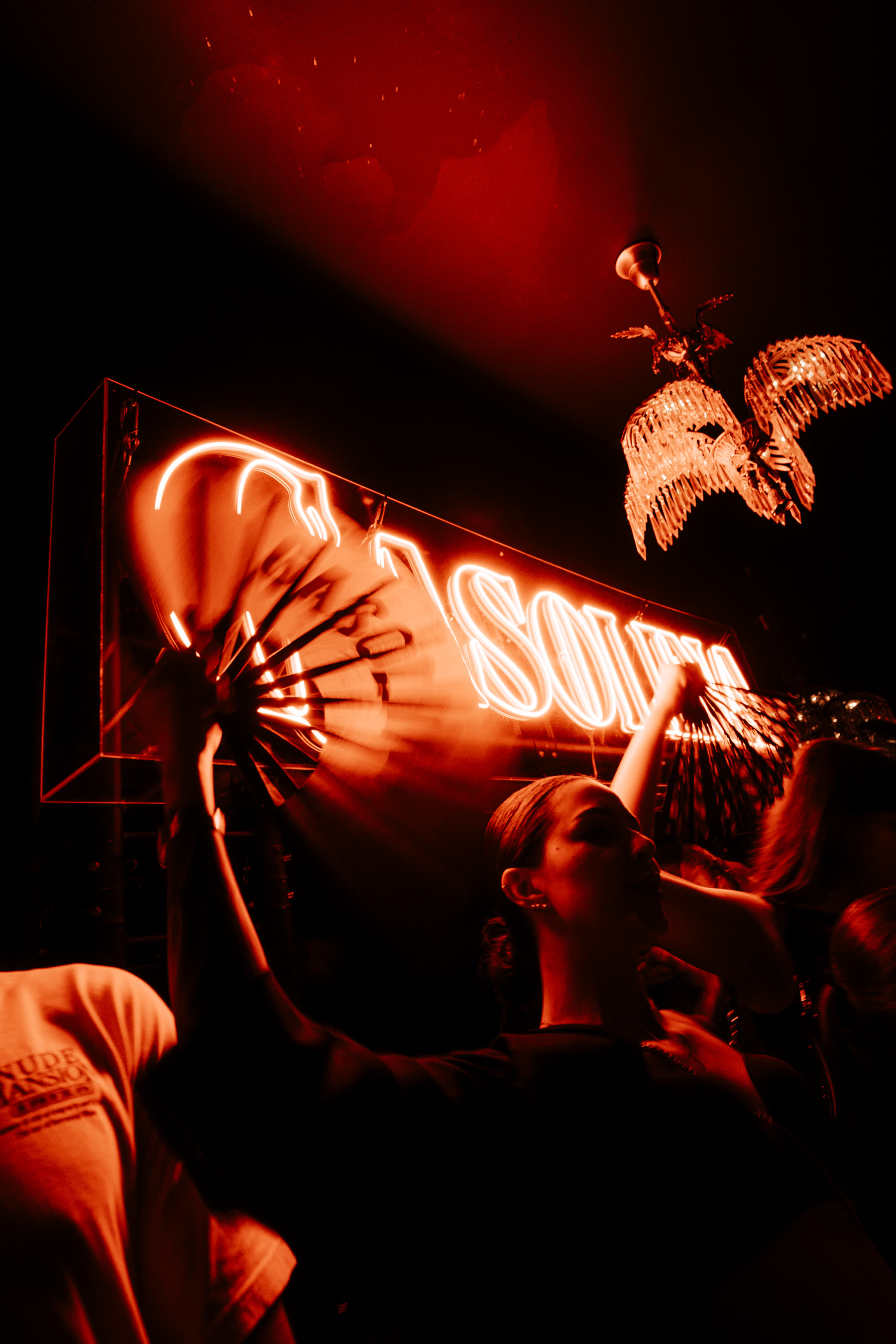 Red light and raised hands during a Gasolina live set